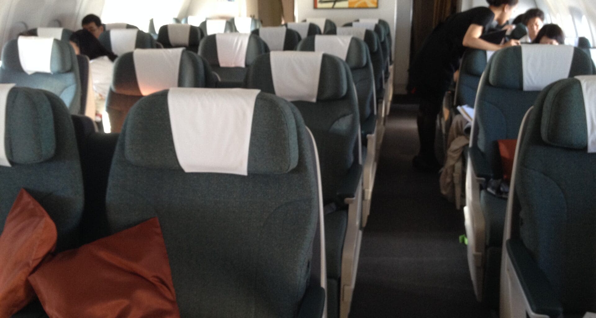 a plane with grey seats and a red pillow