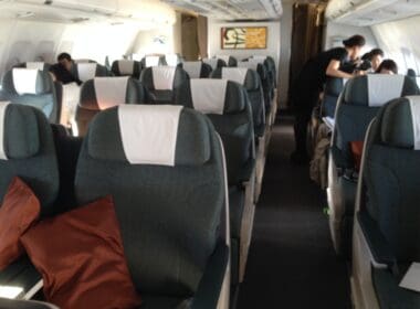 a plane with grey seats and a red pillow