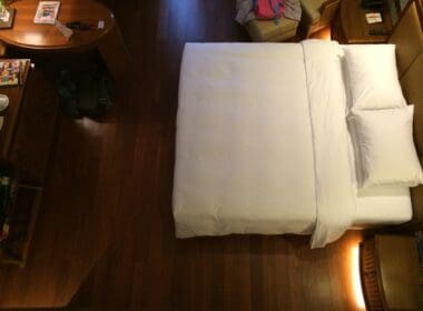 a bed with a white sheet and a table