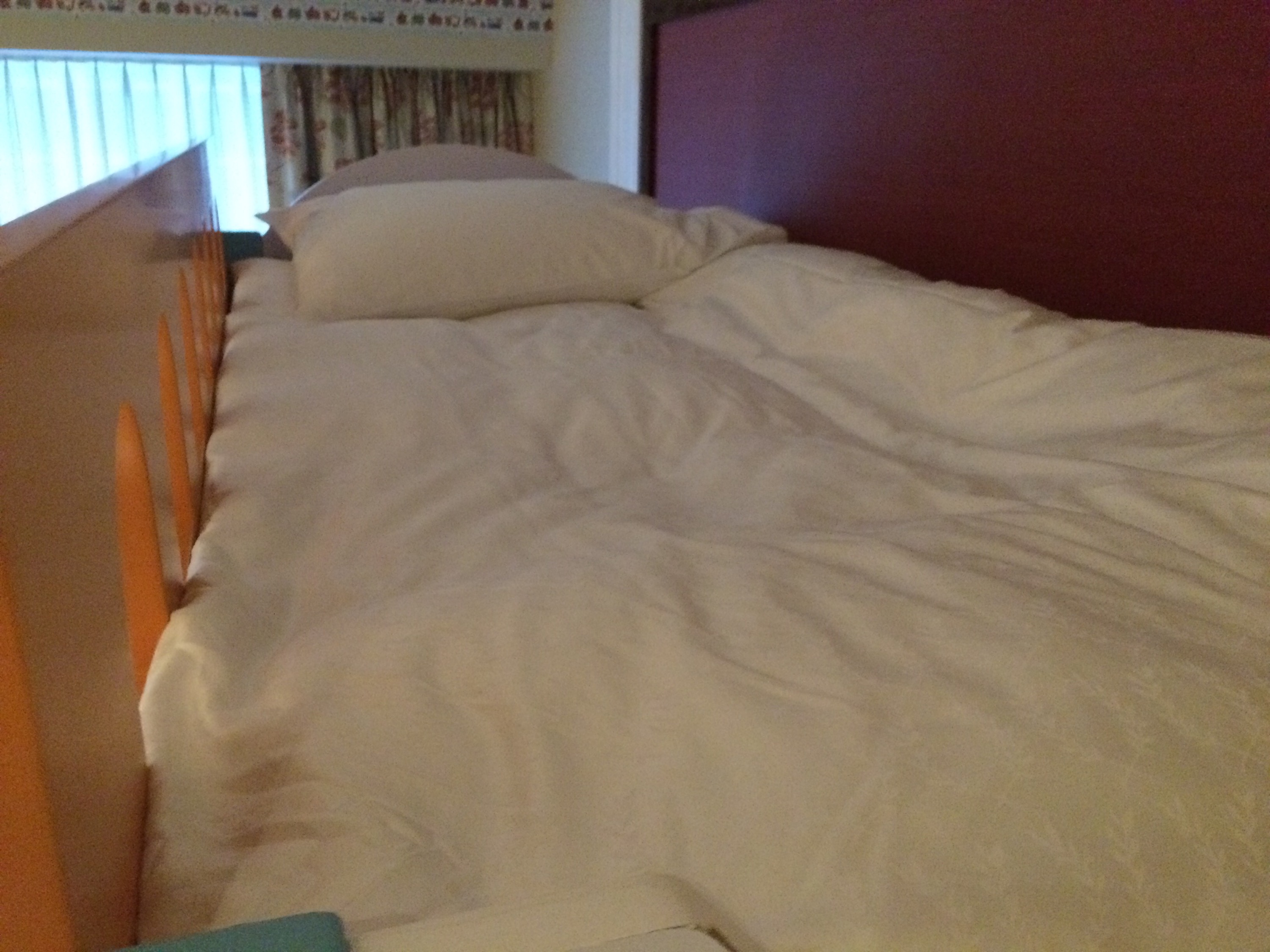 a bed with white sheets and pillows