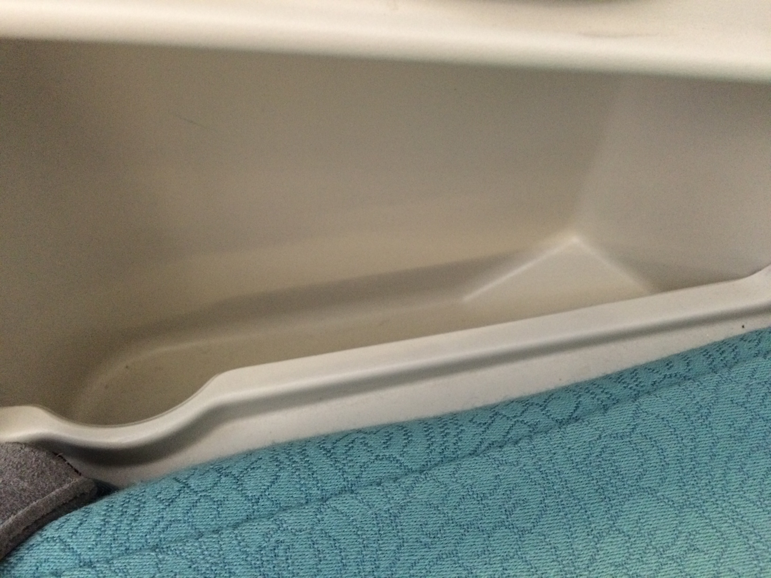 a white plastic bin with a blue fabric surface