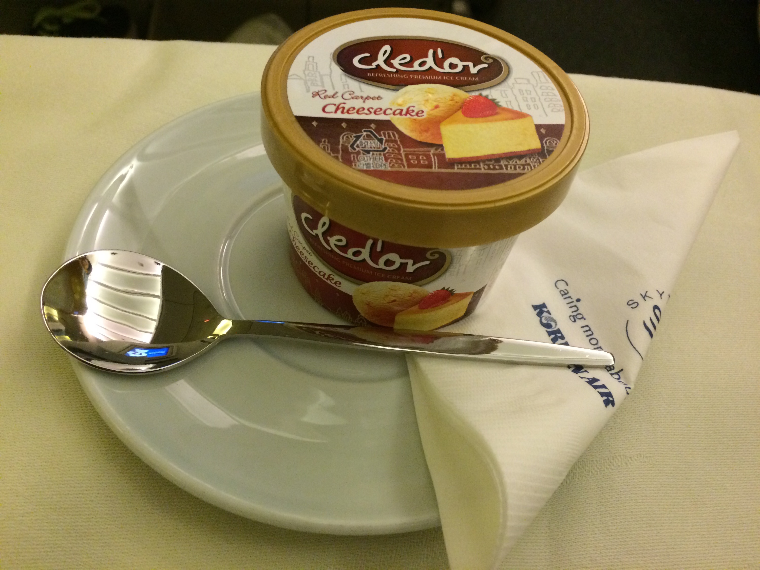 a cup of ice cream on a plate with a spoon