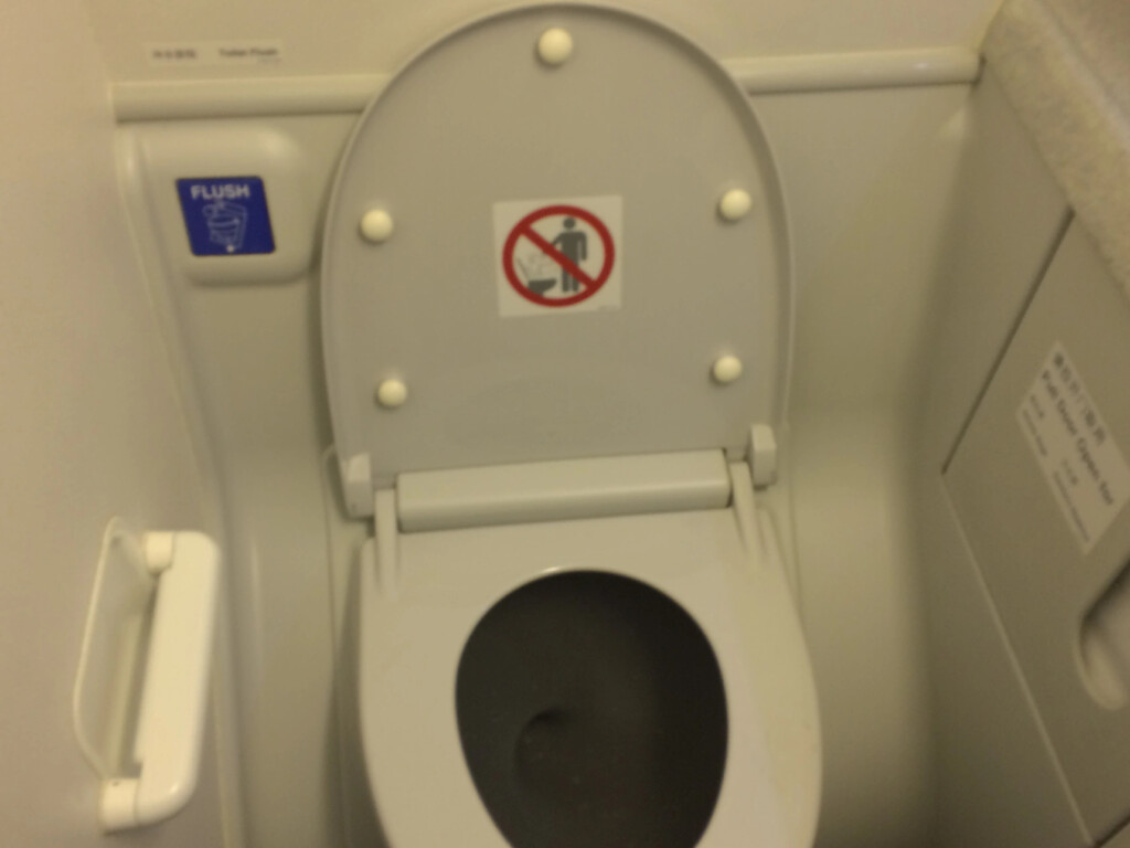 a toilet with a sign on the lid