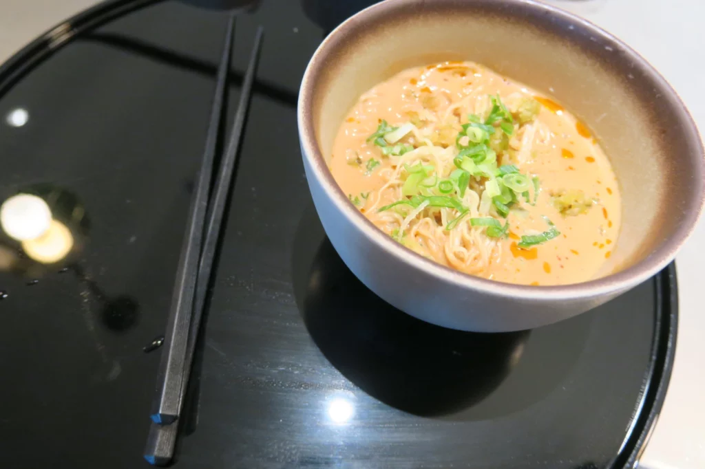 a bowl of soup with chopsticks