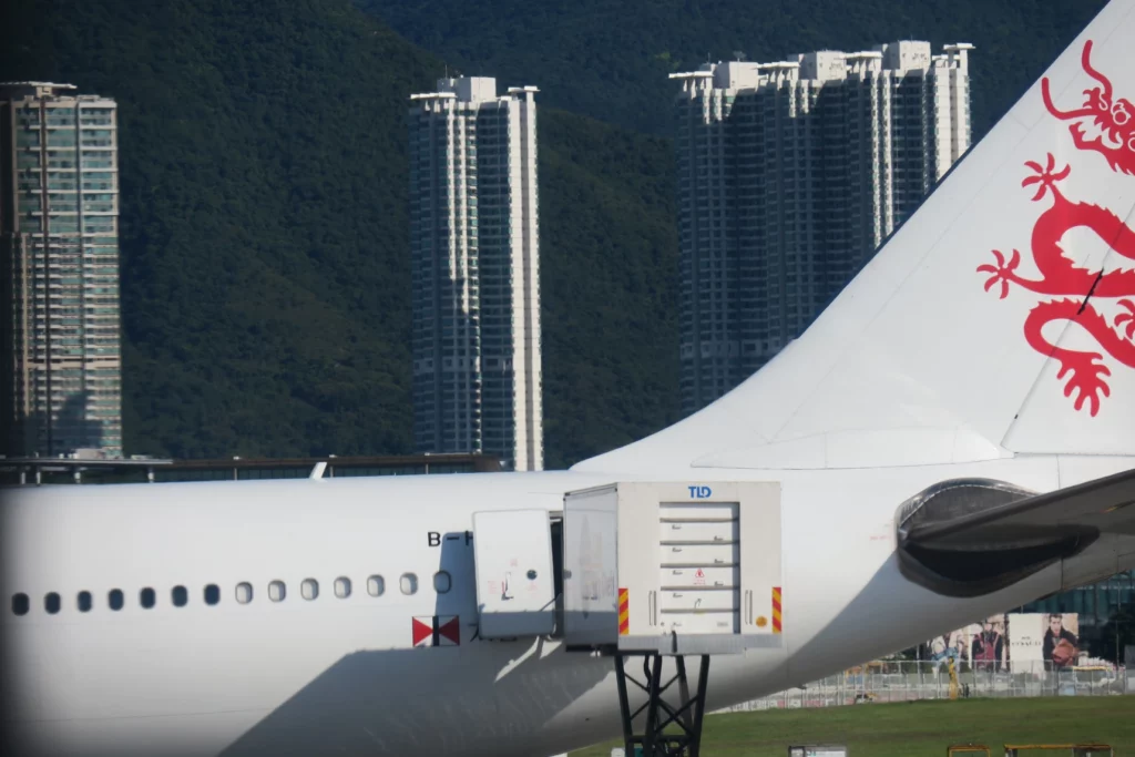 a white airplane with buildings in the background