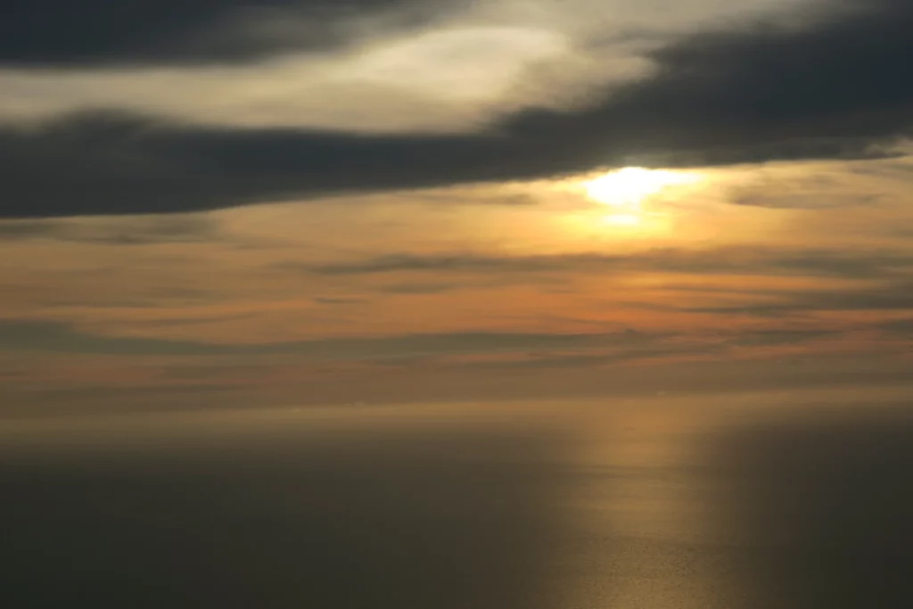 a sunset over water with clouds