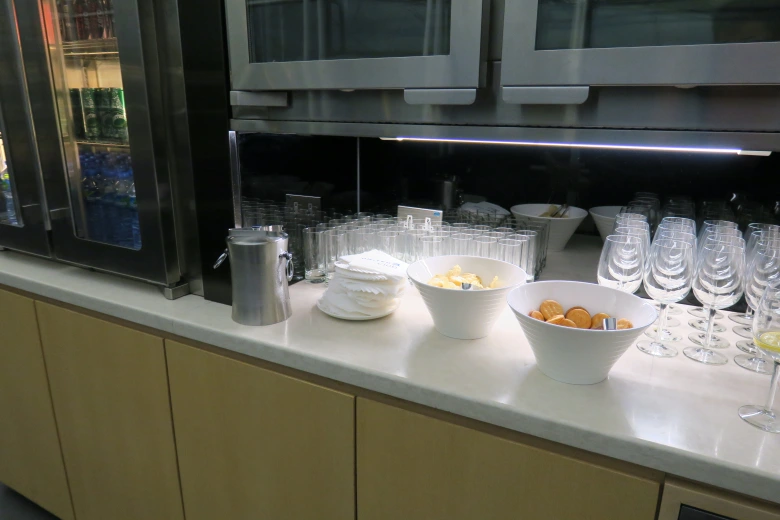 a kitchen counter with a few bowls of food and glasses