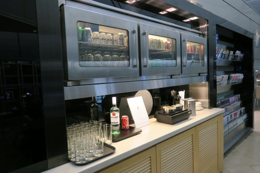 a refrigerator with drinks and glasses on a counter