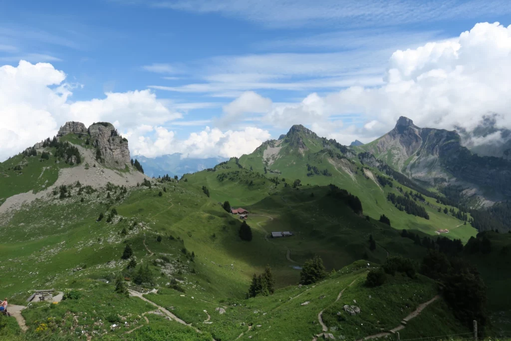 a green mountain range with a house and trees