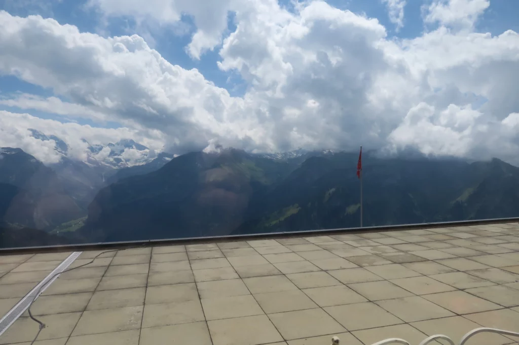 a view of mountains and clouds from a balcony