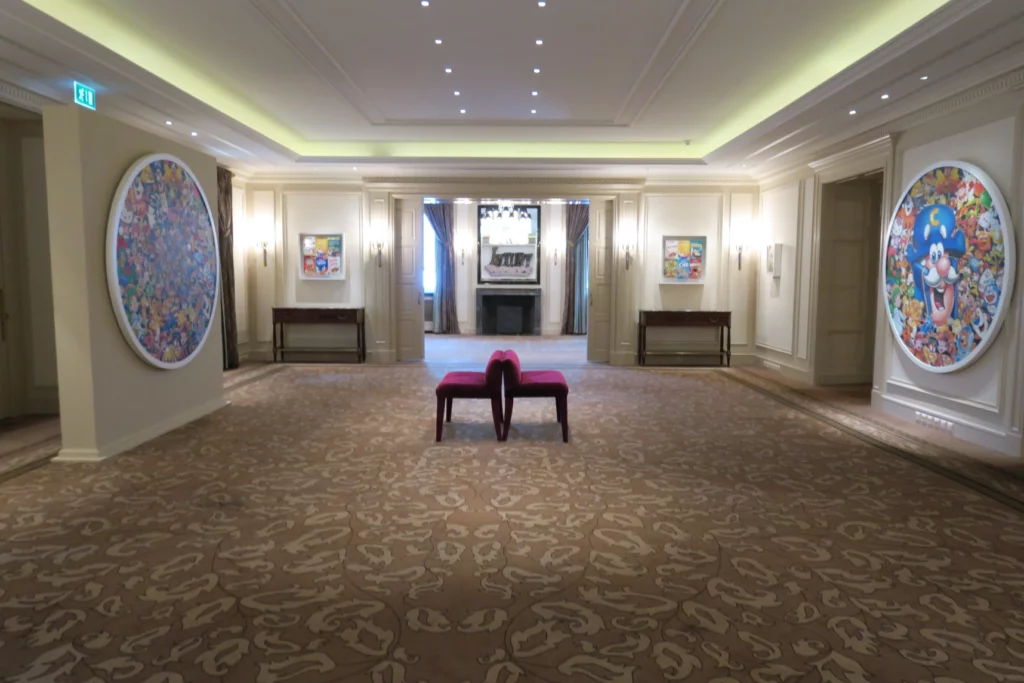 a room with a red bench and a large round painting on the wall