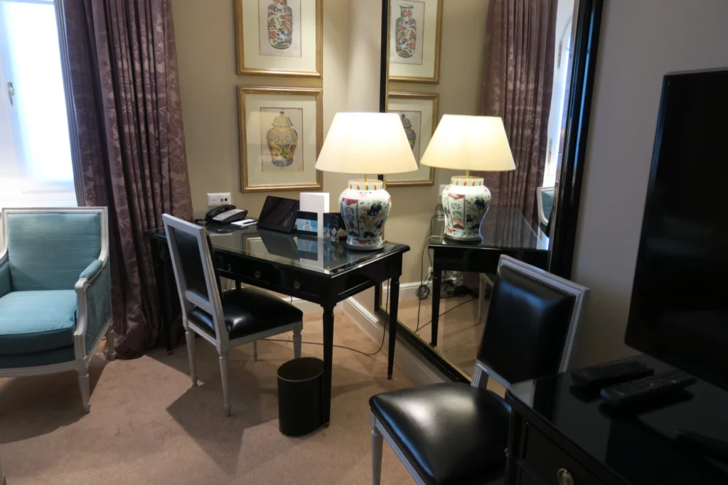 a desk with lamps and chairs in a room