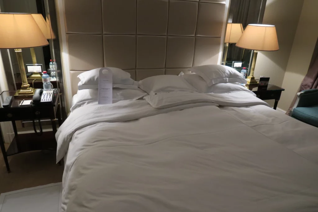 a bed with white sheets and pillows