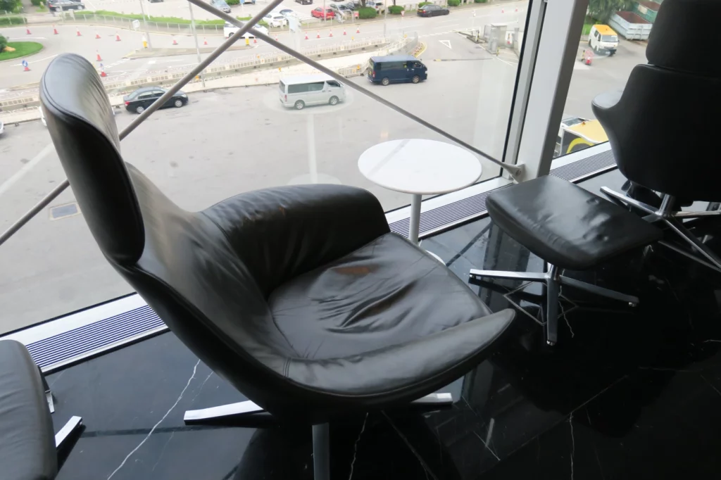 a black chair and a table in a room with a view of a street