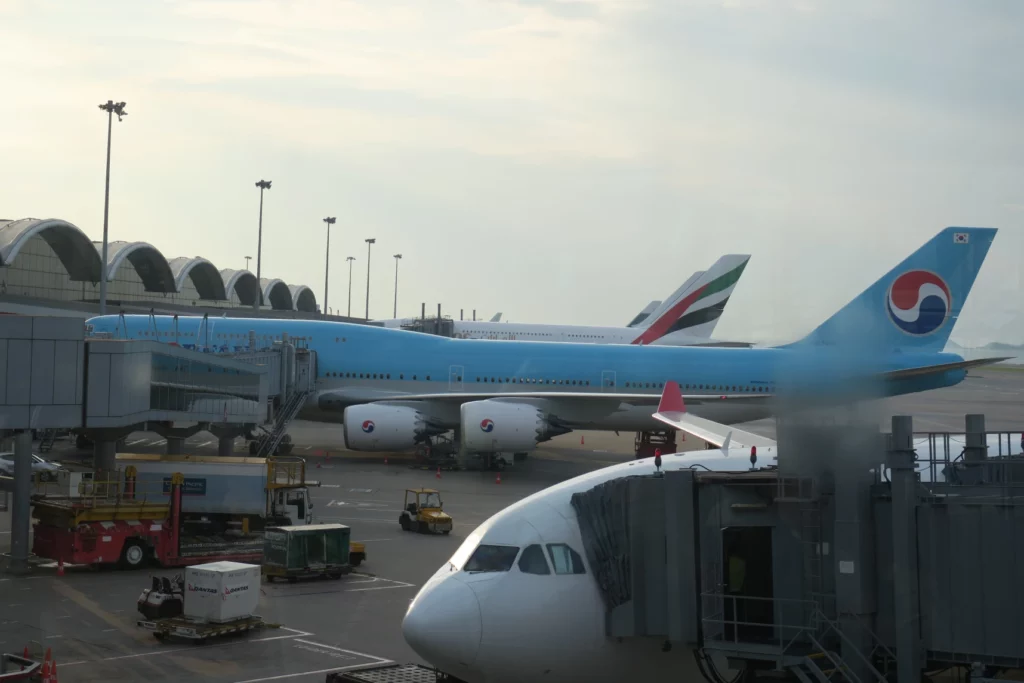 a blue airplane and a plane at an airport