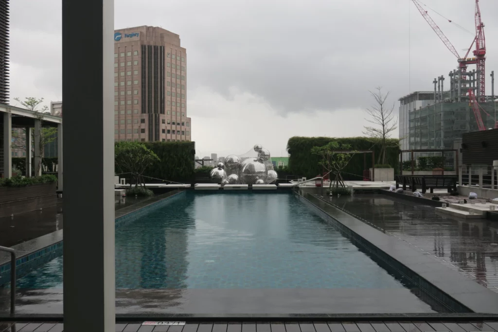 a pool with a statue in the background