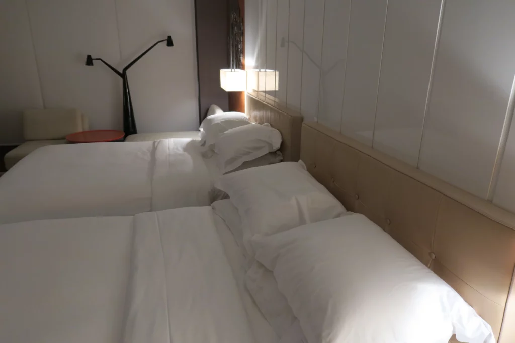 a bed with white sheets and pillows