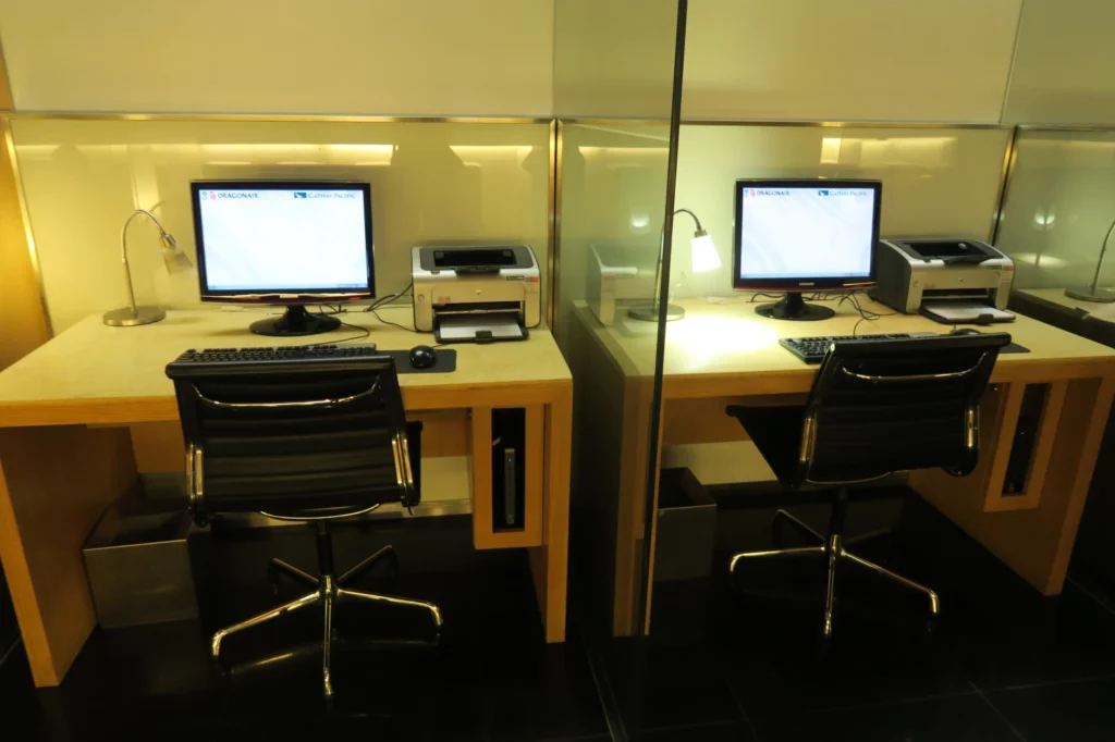 a desk with computers and a printer