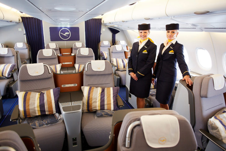 a couple of stewardesses standing in an airplane