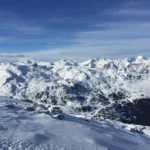 a snowy mountain range with blue sky