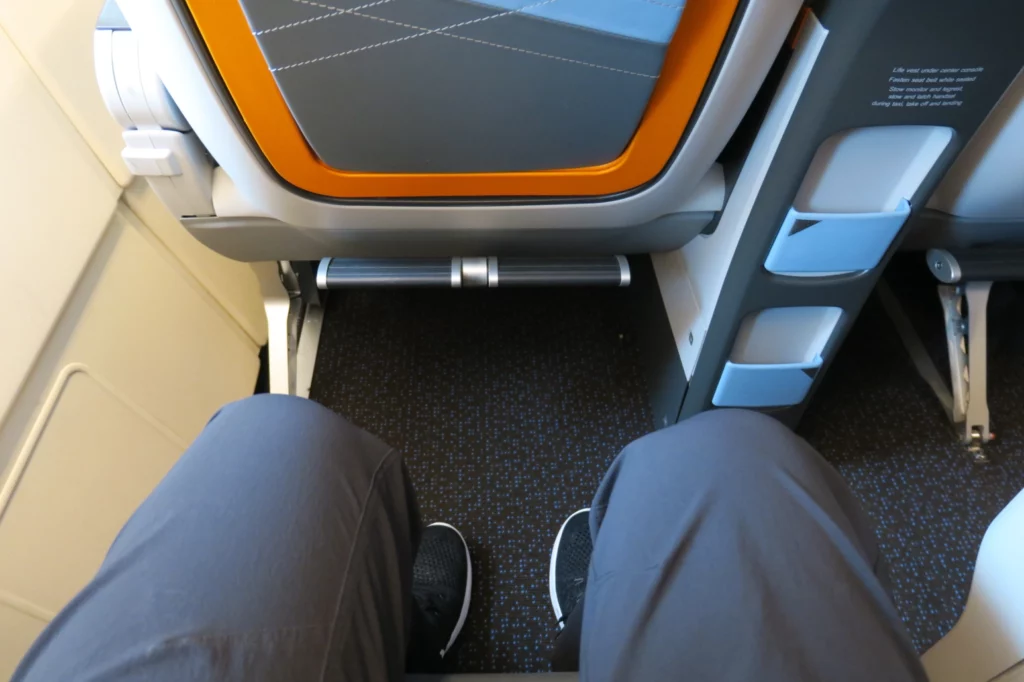 a person's legs and feet in an airplane