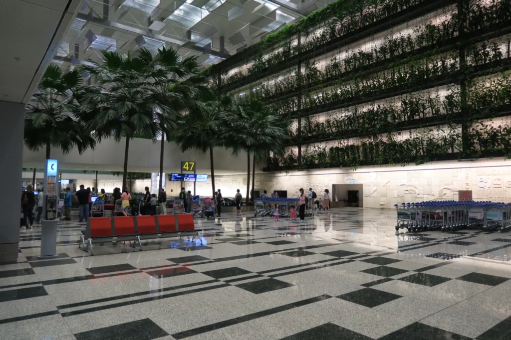 a group of people in a building with plants on the wall