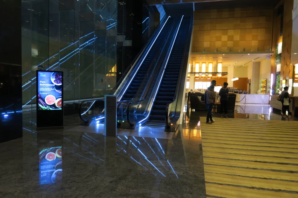 a two people standing next to an escalator