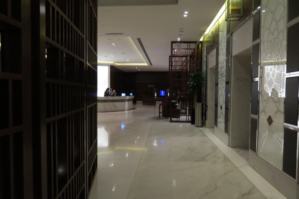 a hallway with a reception desk and people in it