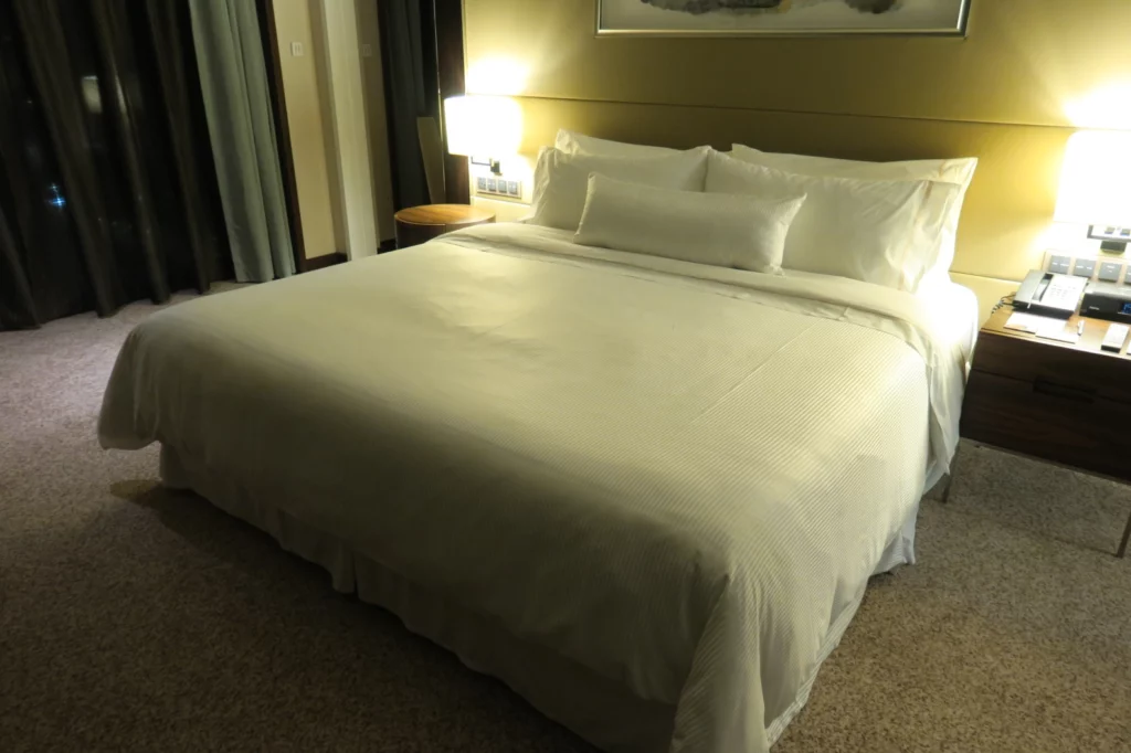 a bed with white sheets and pillows