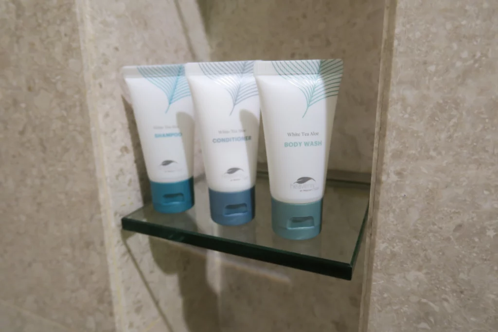 a group of white and blue bottles on a glass shelf