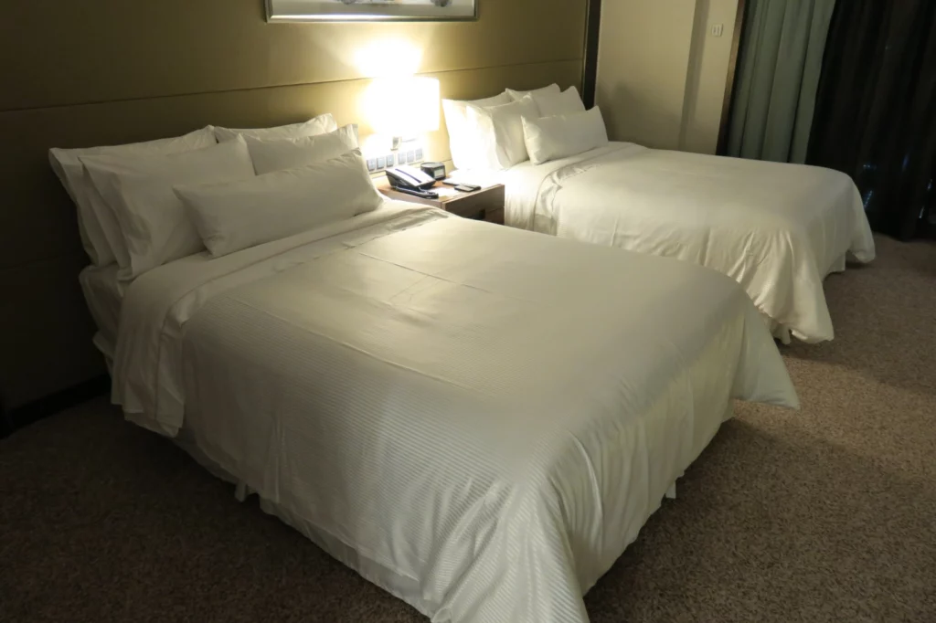 two beds with white sheets