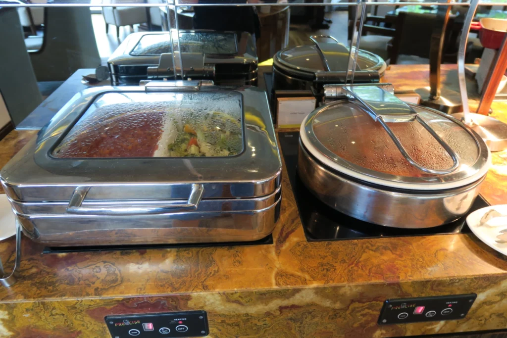 food in a buffet with a glass cover