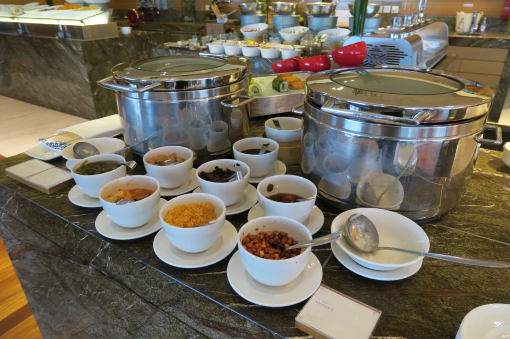 a table with bowls of food and saucers