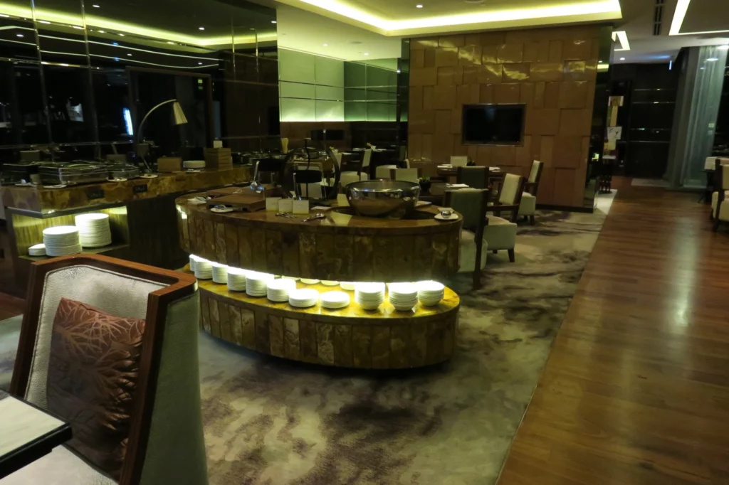 a room with a large round table with white bowls on it