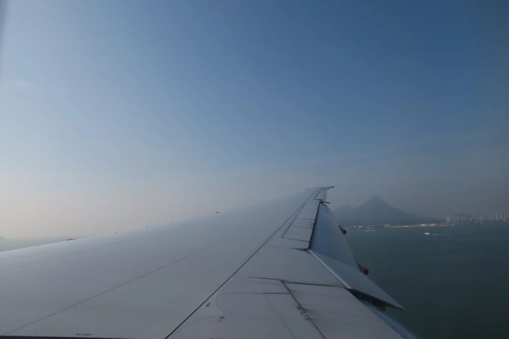 an airplane wing and a mountain in the distance