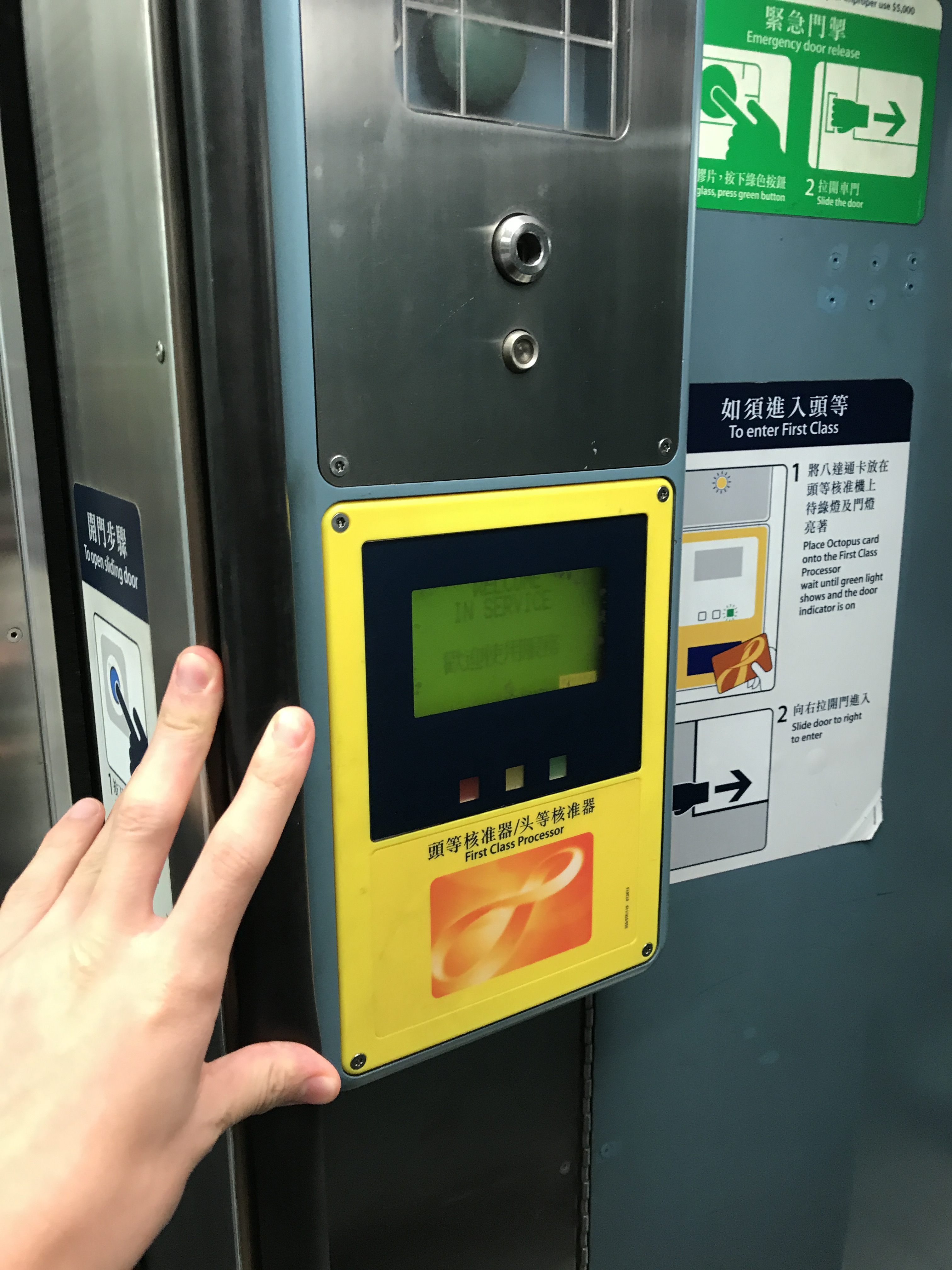 a hand holding a yellow and blue screen on a metal box