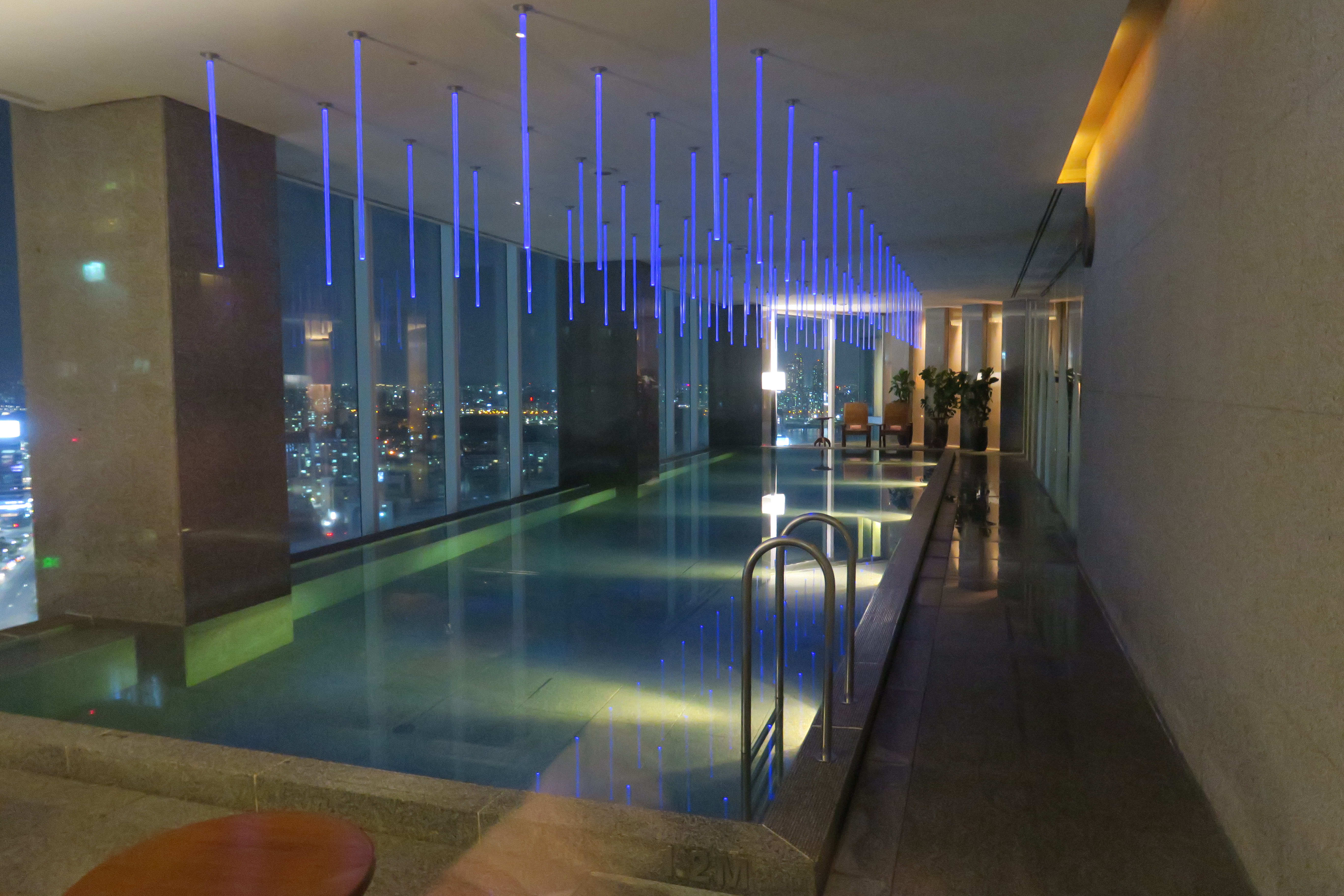 a indoor pool with blue lights from the ceiling