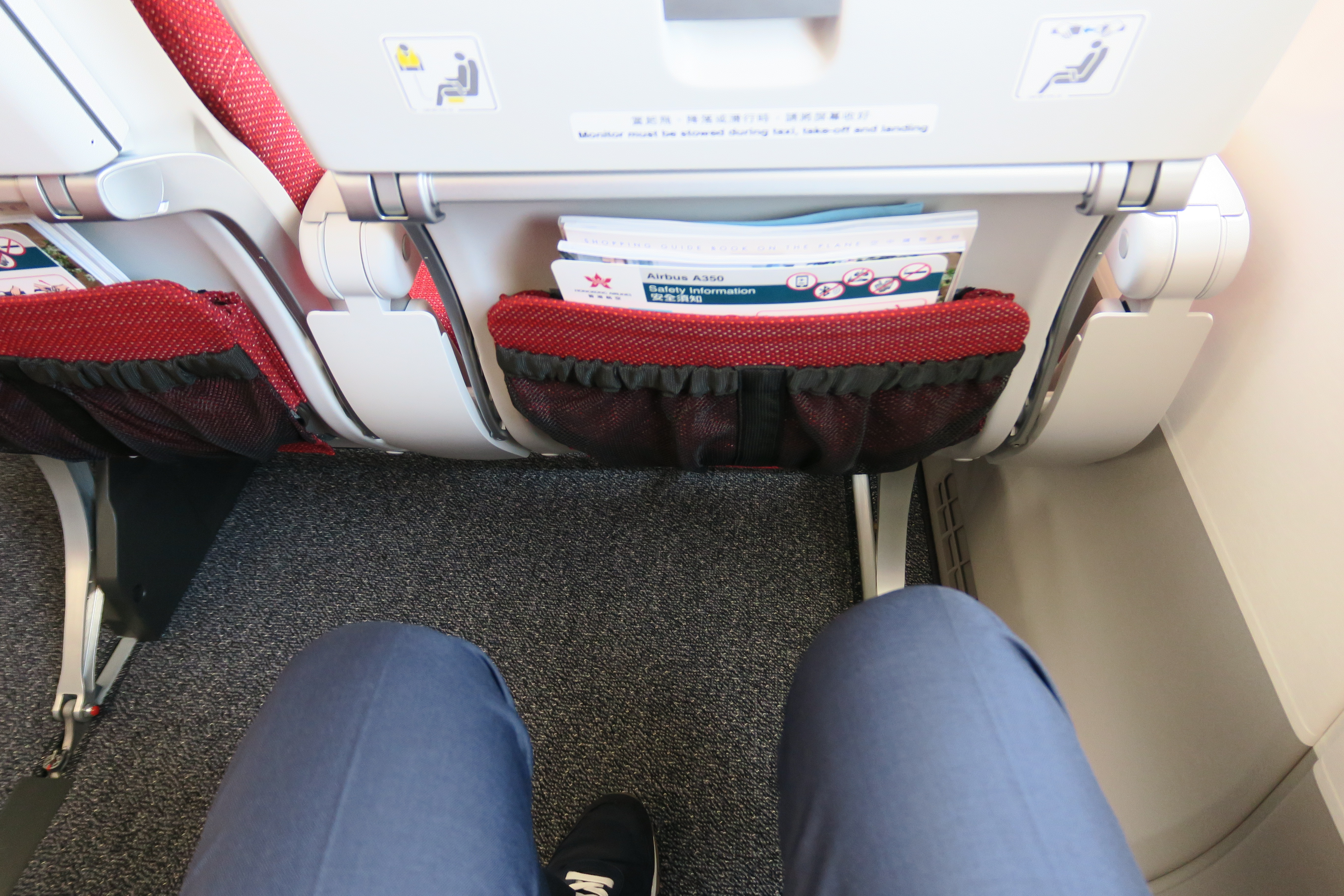 a person's legs in a seat with a pocket in the back