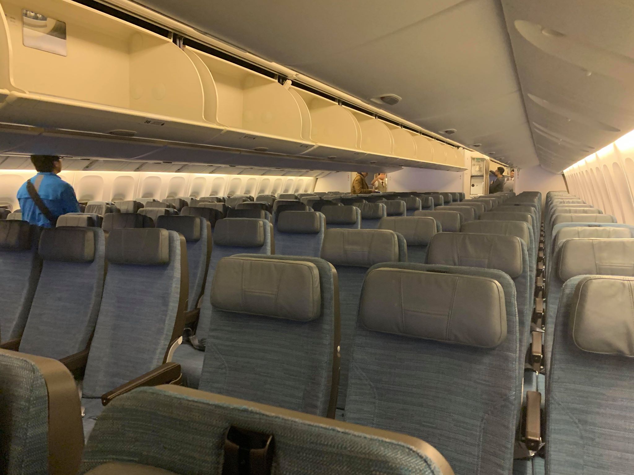 an airplane with seats and a person standing in the background