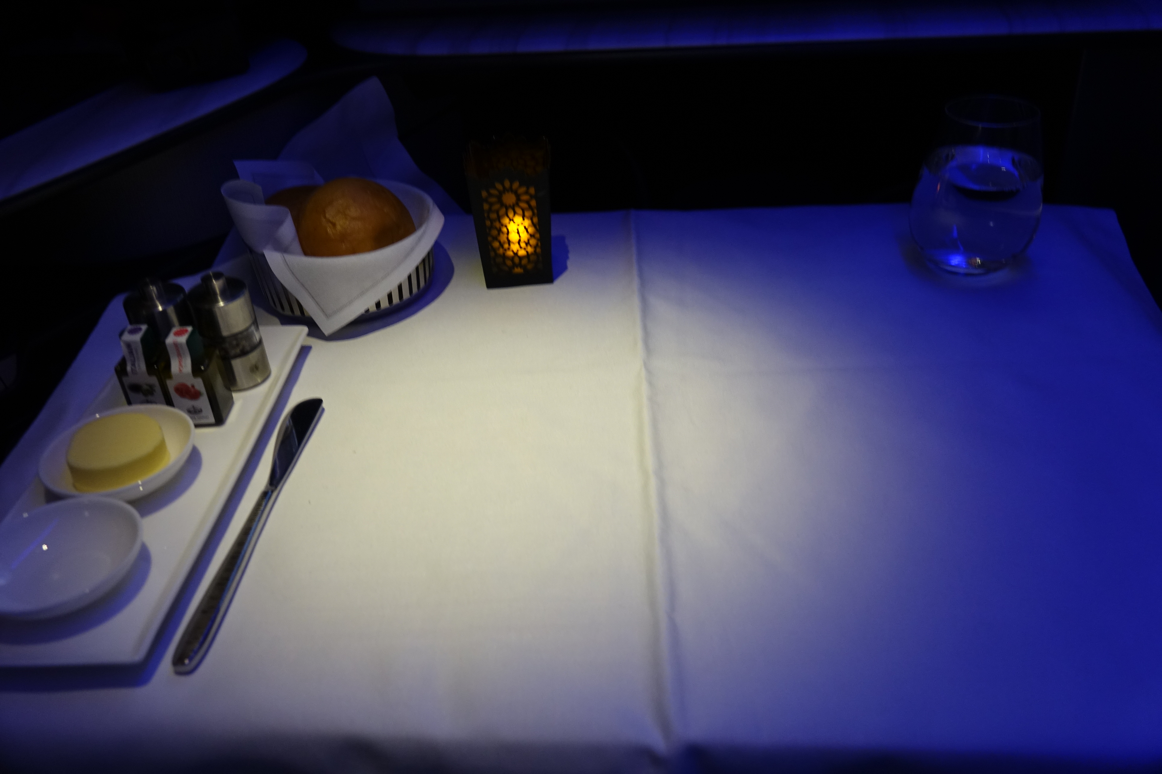 a table with a candle and a bowl of bread