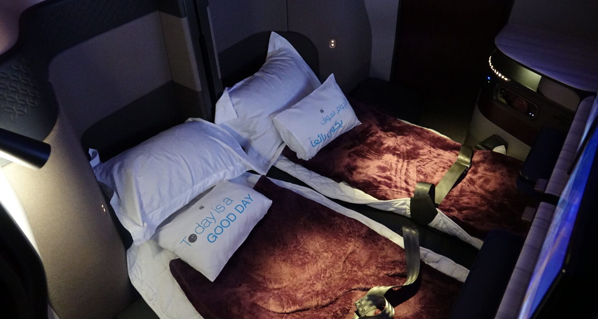 two beds with pillows and straps on them