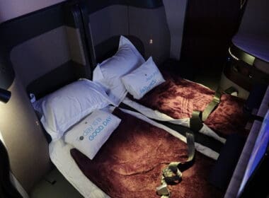 two beds with pillows and straps on them