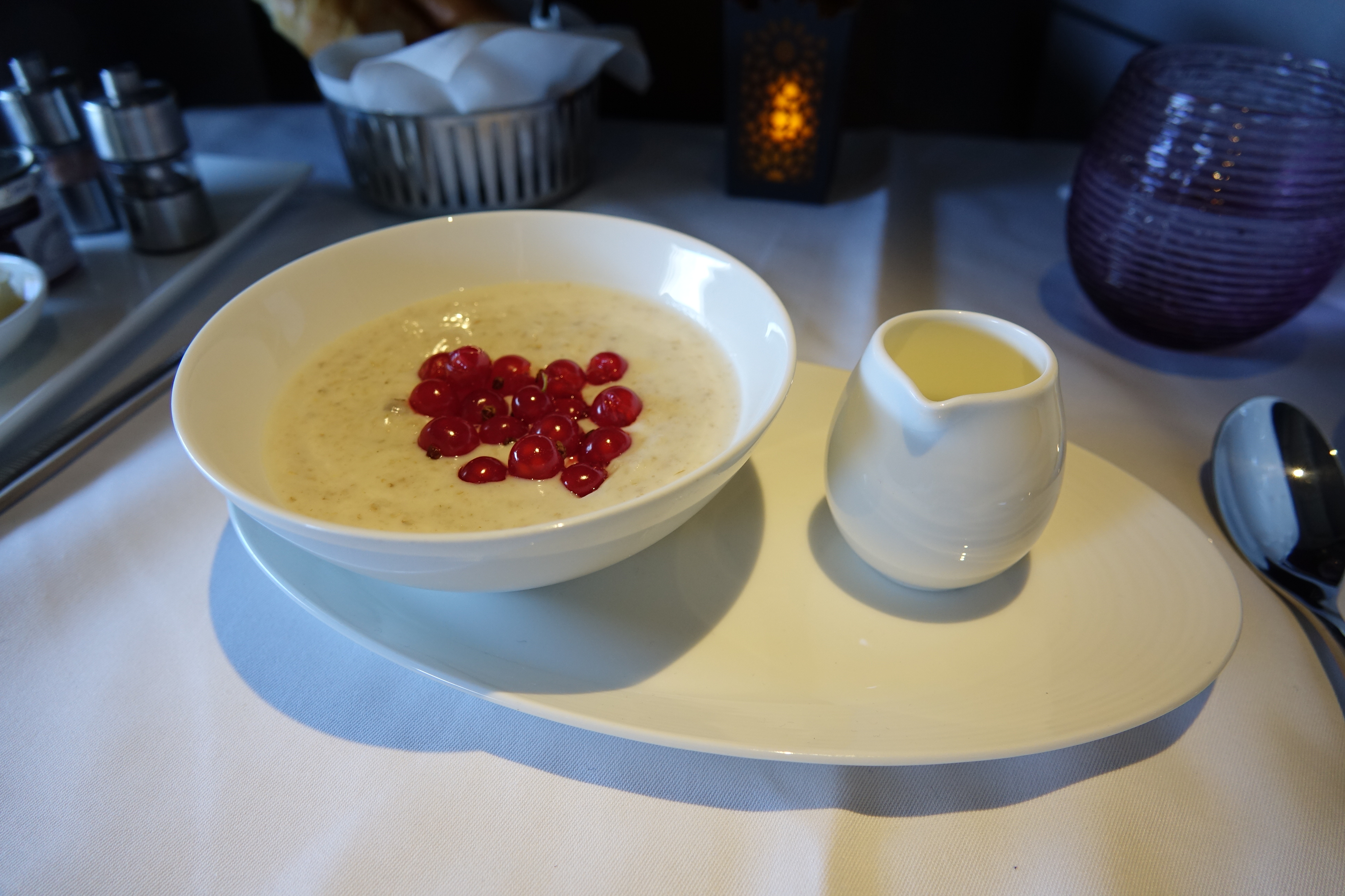 a bowl of oatmeal with red berries on a plate