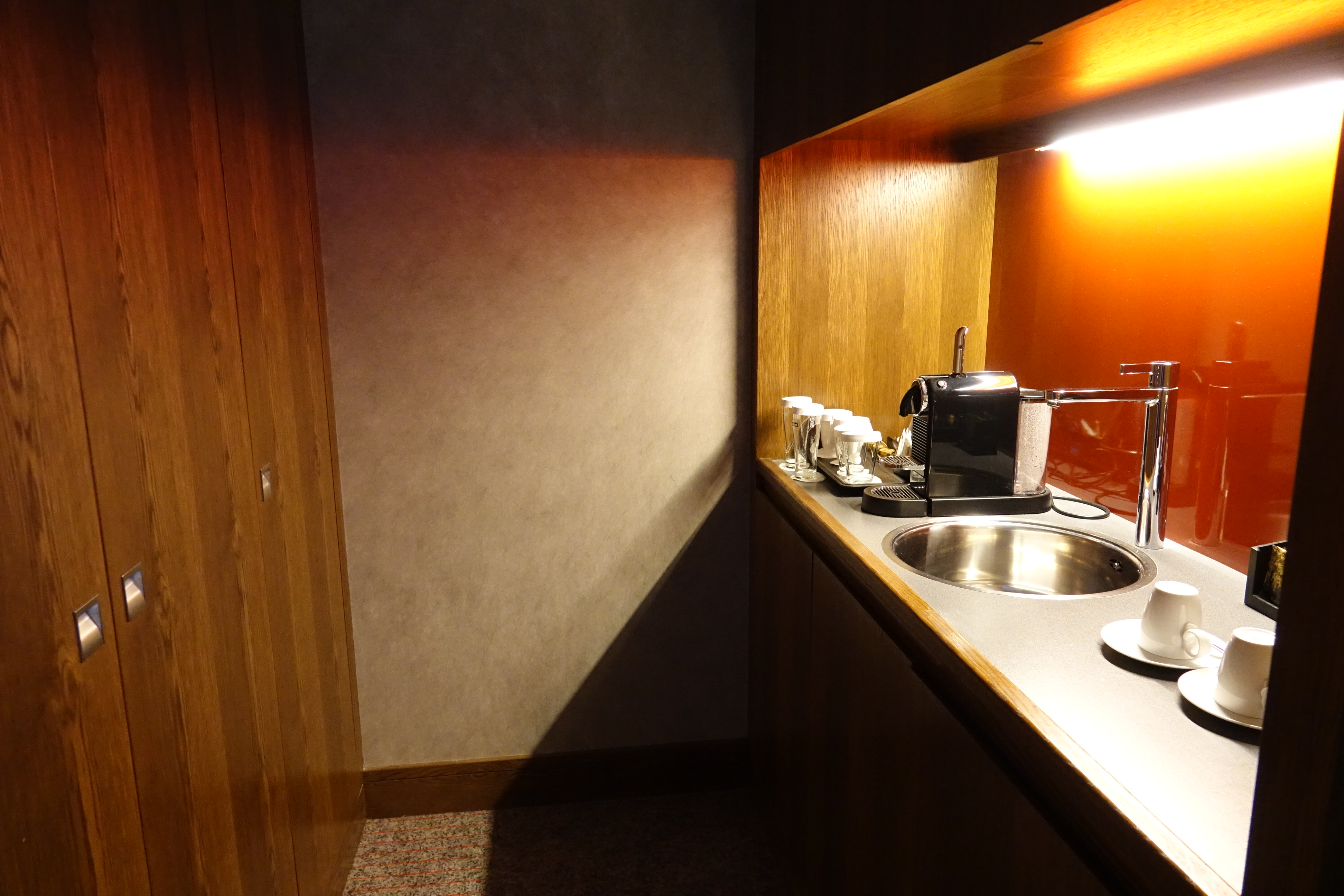 a kitchen counter with a sink and a coffee maker