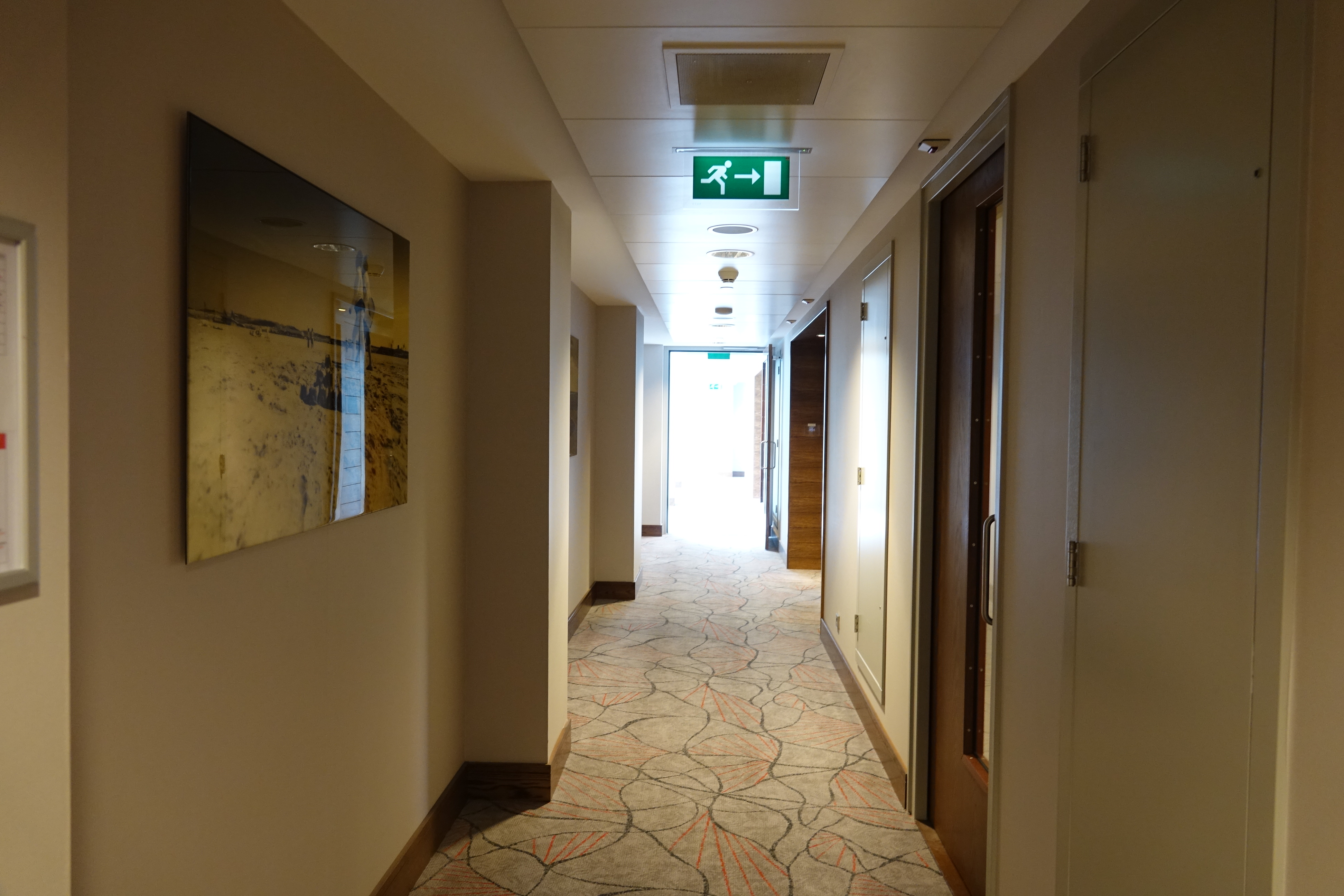 a hallway with a green sign