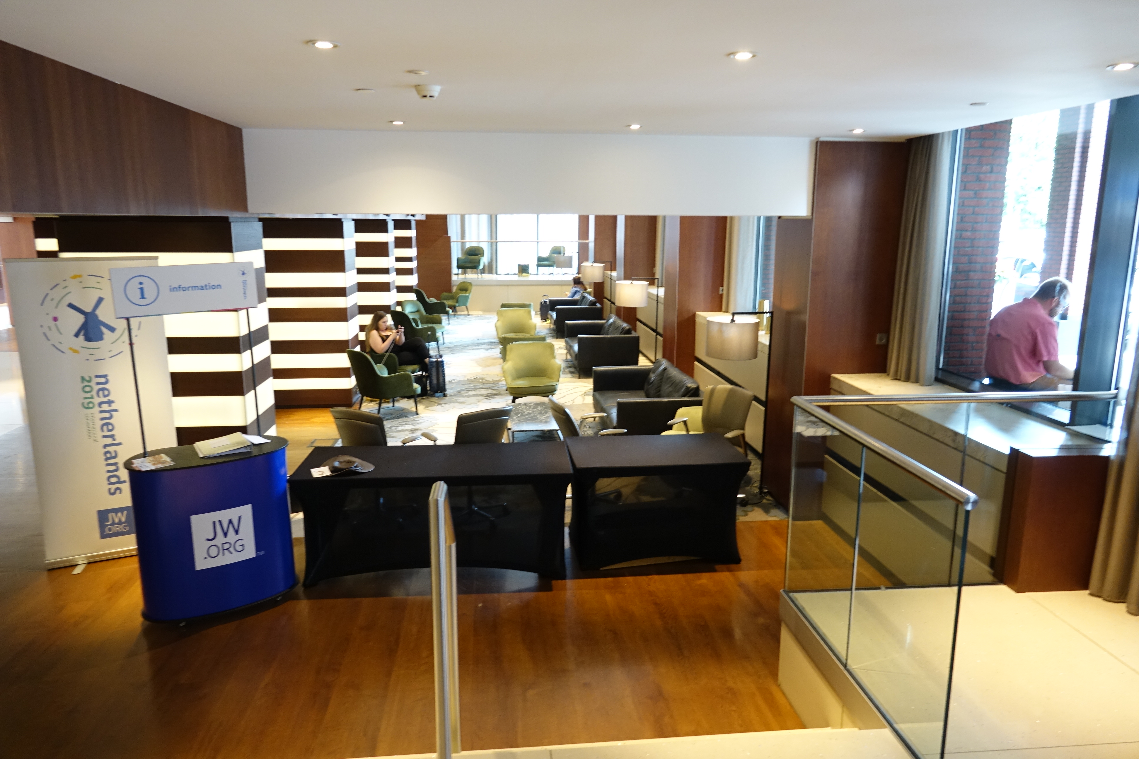 a room with a glass case and a person sitting on a couch