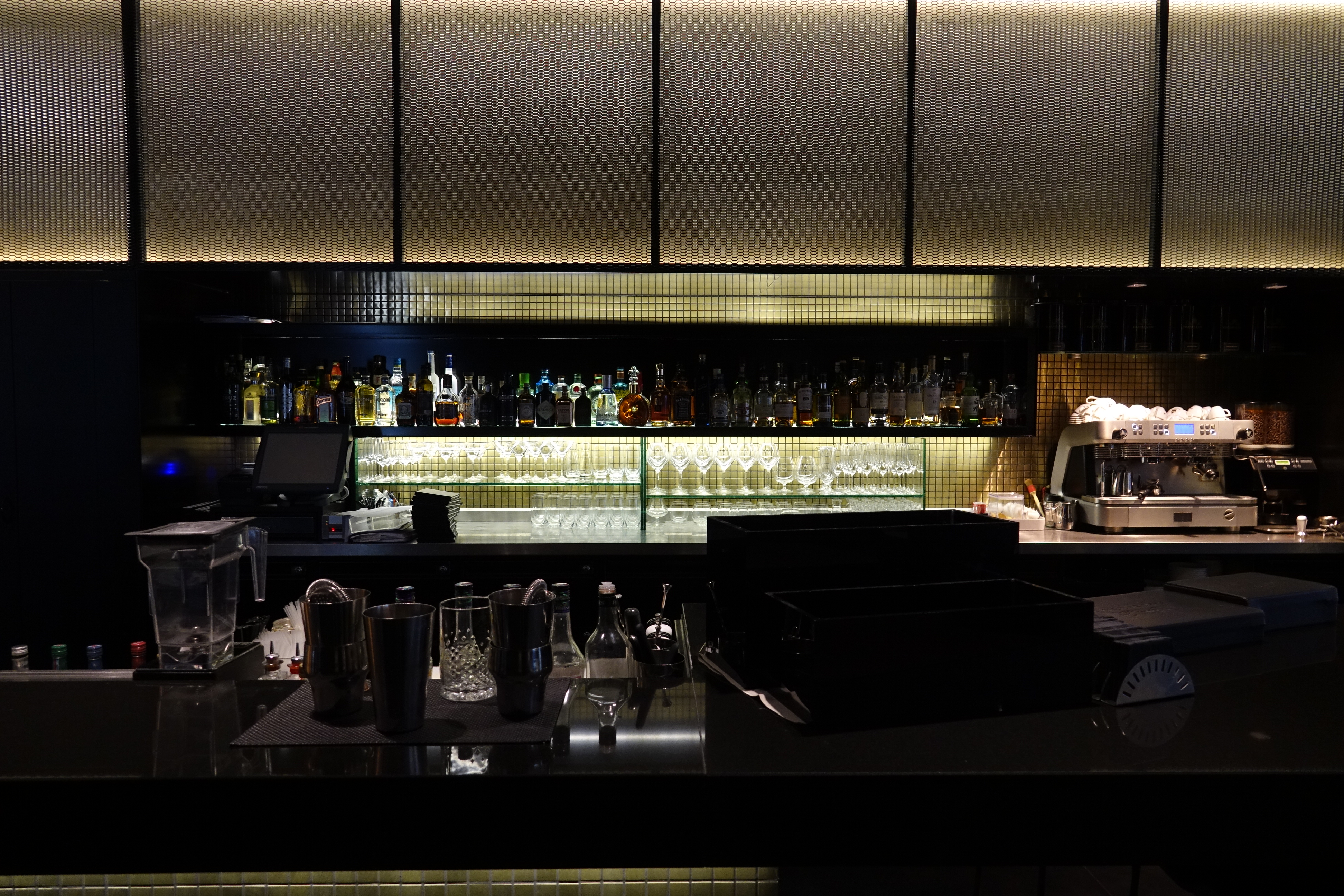 a bar with a counter and bottles of alcohol