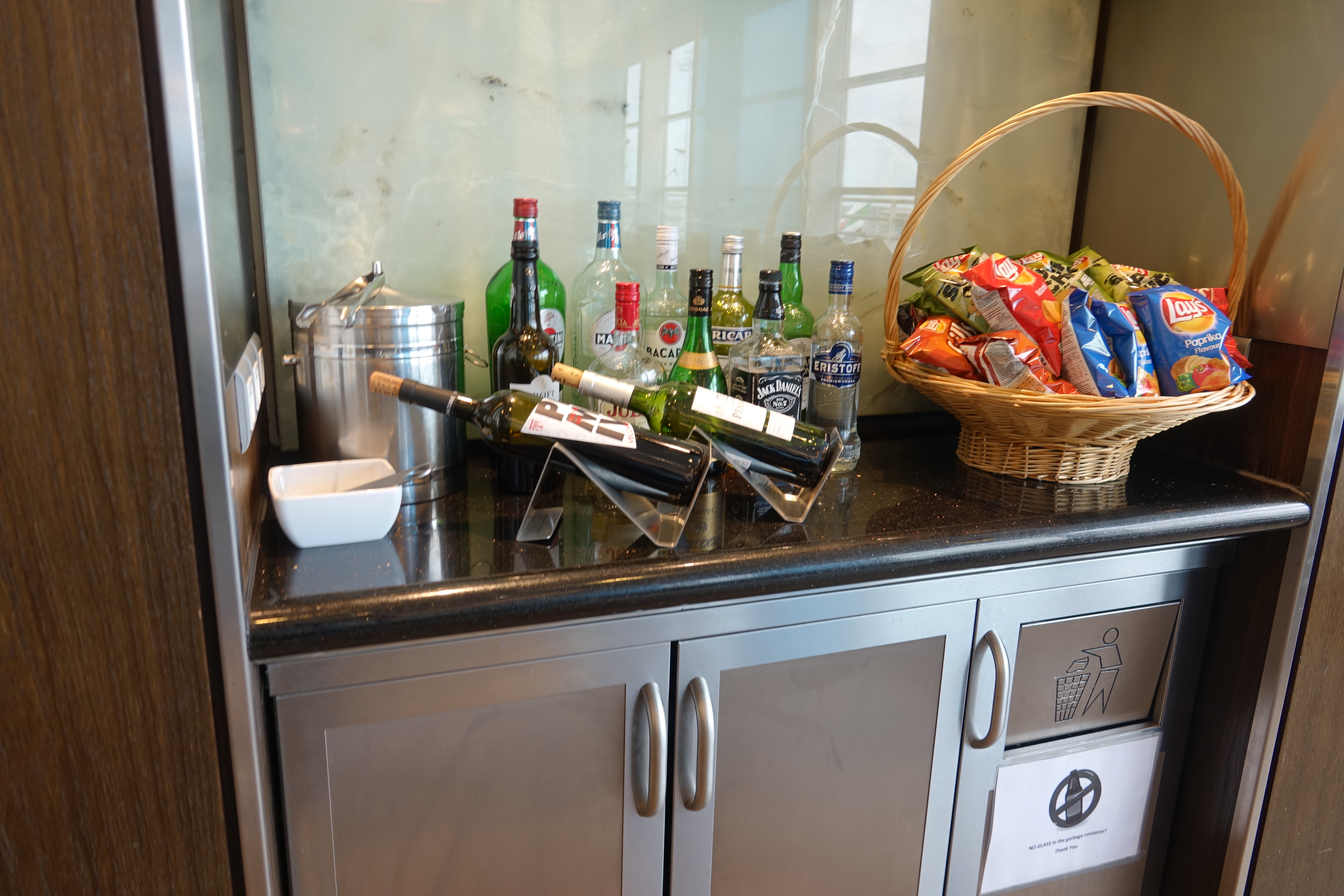 a group of bottles and a basket of snacks on a counter