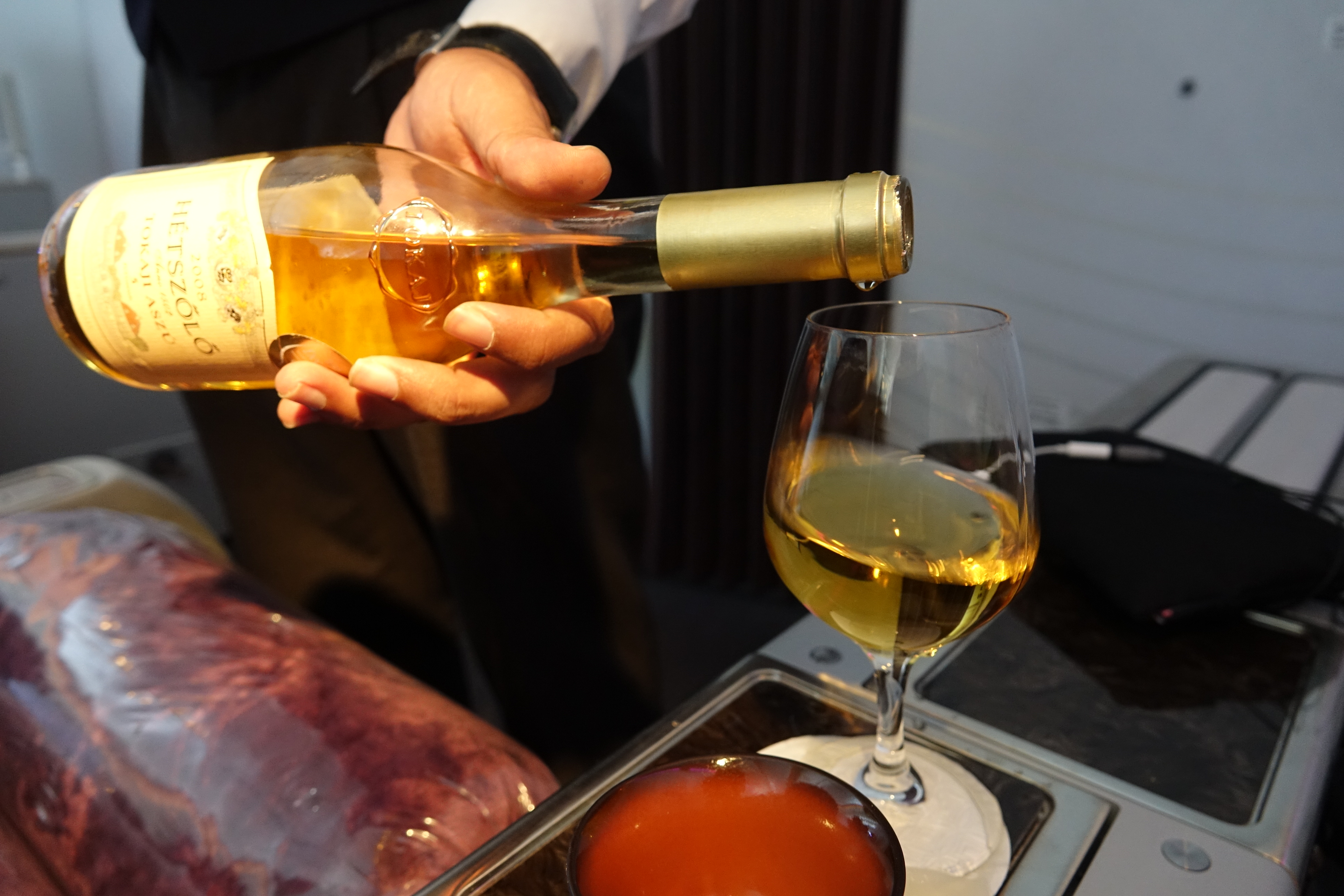 a person pouring a glass of wine