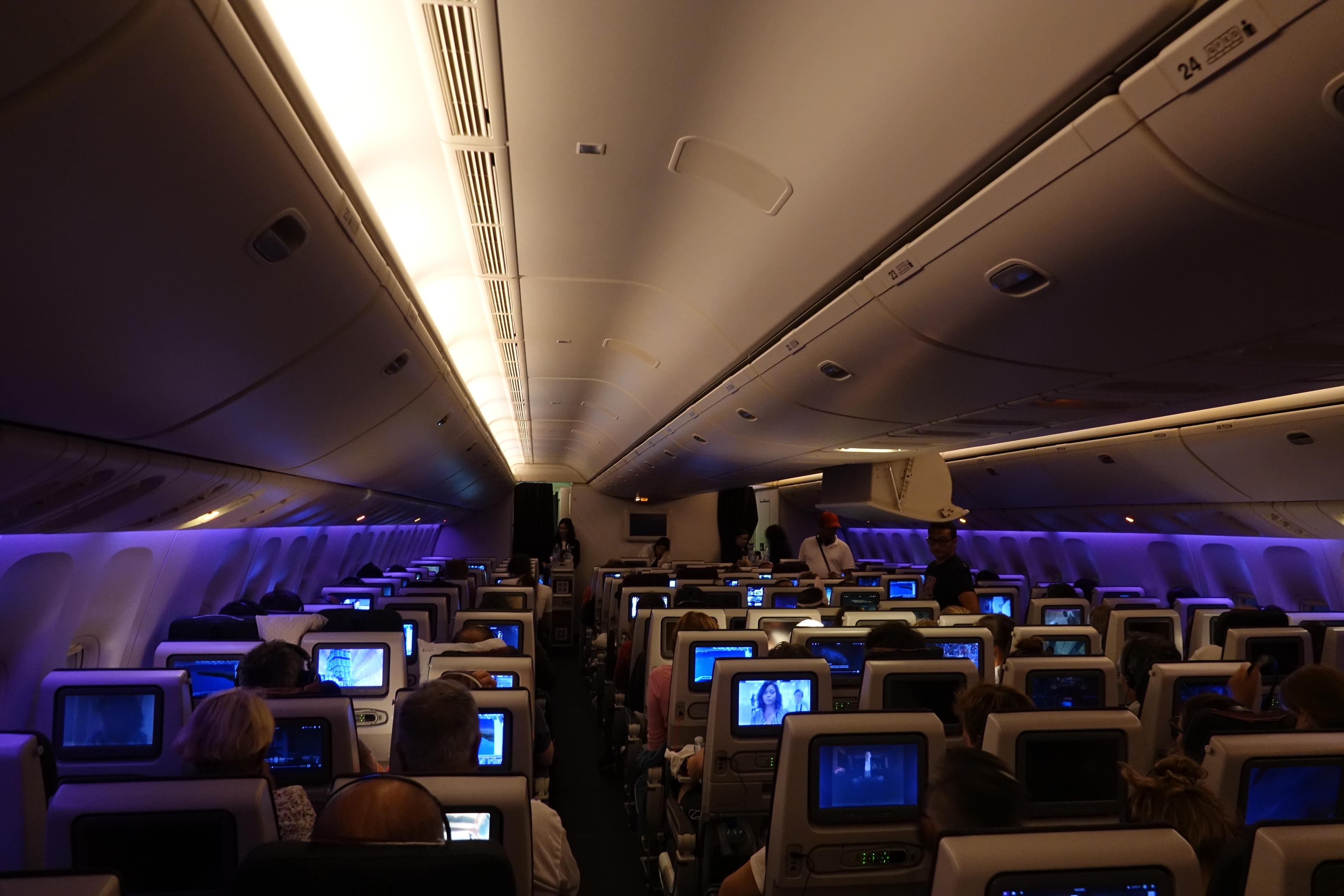 a group of people sitting in an airplane with monitors